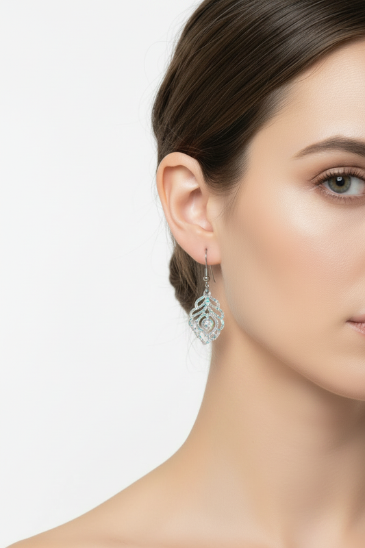 Clear iridescent ornate swirl earrings on model - 20% smaller